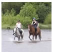 Instructor and student riding through water